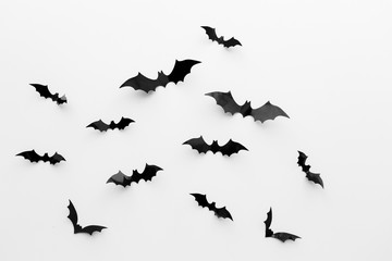 black paper bats over white background