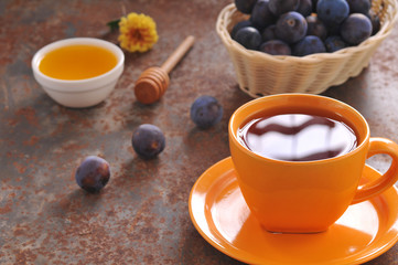 A cup of tea and plum on the table