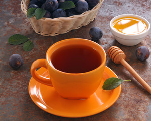 A cup of tea and plum on the table