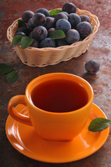 A cup of tea and plum on the table
