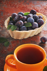 A cup of tea and plum on the table