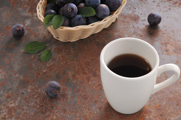 A cup of tea and plum on the table