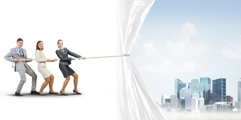 Obraz premium Young businesspeople working in collaboration and pulling white advertisement banner