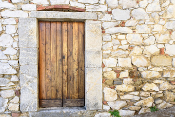 old wooden door on stone wall - 169045085