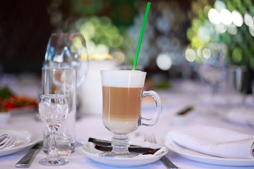 Fancy latte coffee in glass jar on restaurant background