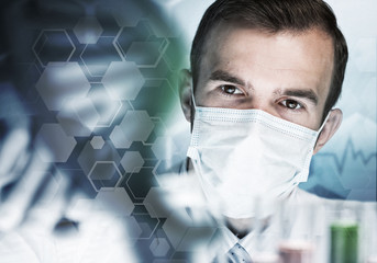 Young scientist mixing reagents in glass flask in clinical laboratory