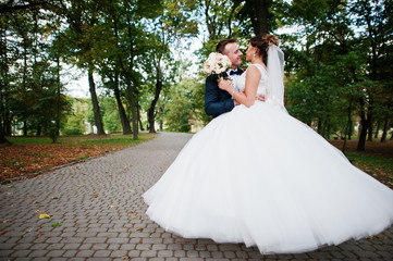 Good-looking newly married couple walking and enjoying each other's company in the park on a bright...