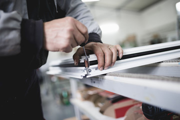Manual worker assembling PVC doors and windows. Manufacturing jobs. Selective focus. Factory for aluminum and PVC windows and doors production.