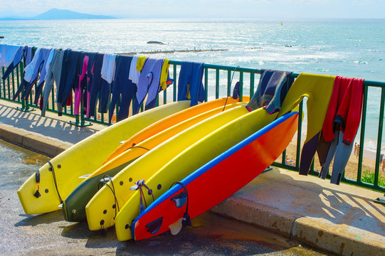 Surfboards and wetsuits at beach