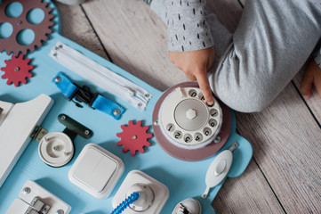 cute toddler baby playing with busy board at home