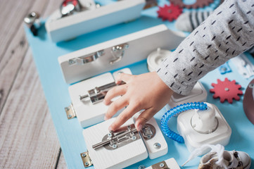 cute toddler baby playing with busy board at home