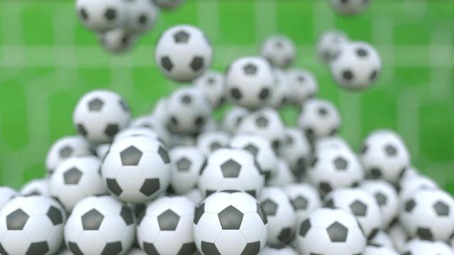 Falling football balls against green field background