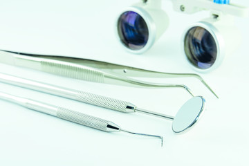 Photo dental instruments mirror, probe, tweezers, mask, binocular glasses magnifier, model of human...