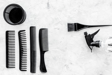 hairdresser working desk with combs, tools for hair styling on gray stone desk background top view...