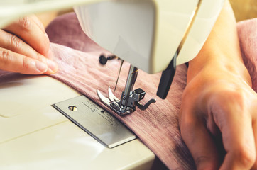 Sewing process close-up on the sewing machine. The presser foot and needle of the sewing machine during operation.