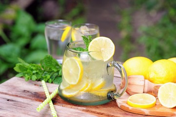 Cold summer drinks in the garden, cold lemonade with lemon and mint