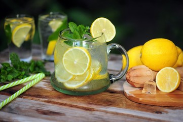 Cold summer drinks in the garden, cold lemonade with lemon and mint