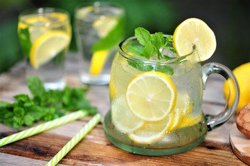 Cold summer drinks in the garden, cold lemonade with lemon and mint