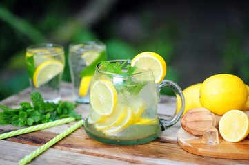 Cold summer drinks in the garden, cold lemonade with lemon and mint