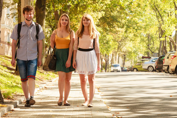 Three people friends walking outdoor.