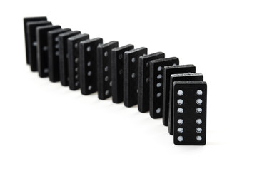 old black dominoes in a row isolated on a white background, selective focus and narrow depth of field