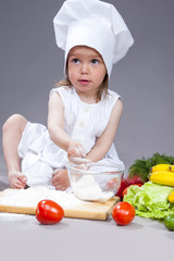 Food Concepts. Little Caucasian Girl in Cook Uniform Making Dishes In Studio.