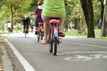 Crowd of people exercising, running and riding bicycle in the national park on a beautiful Sunday morning