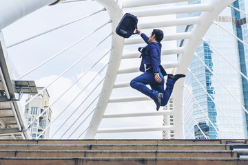 lifestyle business man feel happy jumping in air celebrating  success and achievement  on business district ,  business concept