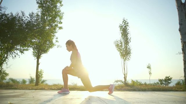Beautiful young woman doing a warm-up in the morning slow motion