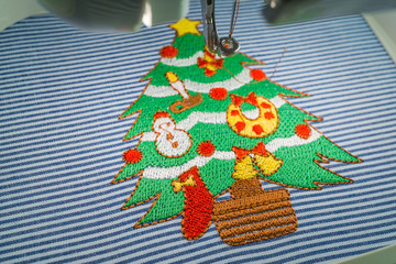 Close up of embroidery machine after embroidered lovely christmas tree full decorations