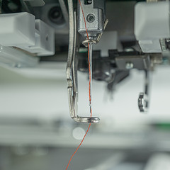 background macro picture of embroidery machines parts close up at holder needleand foot