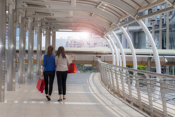 two woman friend walking together with shopping bags in her hand