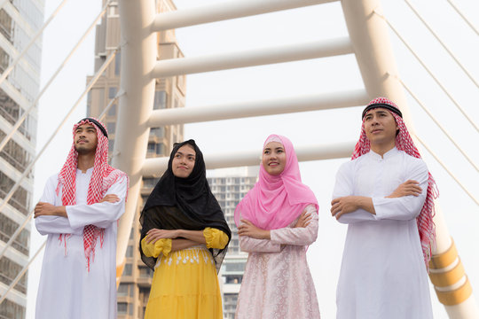Group of Happy Arabian or Muslim young business team cross hands and looking up in public workplace