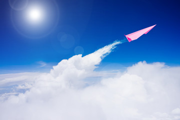 Naklejka na ściany i meble Pink paper plane flying against blue sky