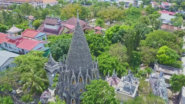 Drone Rotates above Coral Buddhist Temple among Trees Houses