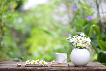 White oval flower pot with white cup and notebook
