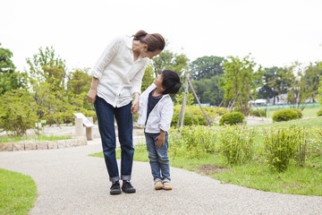 Obraz premium Mother and son looking happy while connecting hands