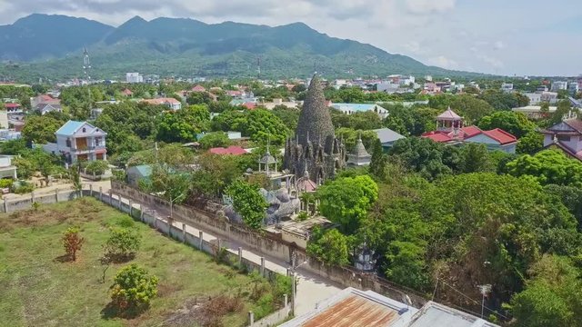Drone Moves to Coral Buddhist Temple Tower against Hill