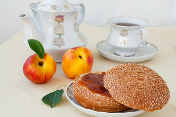 Breakfast on the table: bun with jam from nectarine