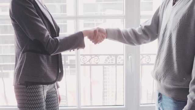 Young woman arriving for a job interview. Business people handshake in modern office. Greeting deal concept