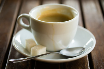A cup of coffee with sugar on the table
