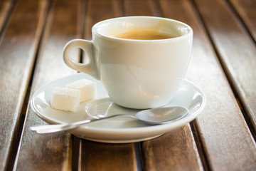 A cup of coffee with sugar on the table
