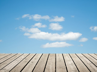 Fototapeta na wymiar wooden floor against the sky with clouds