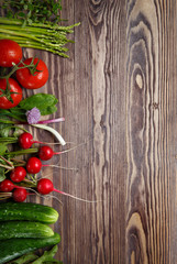 Frame of fresh organic vegetables and herbs on wooden table.