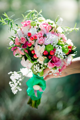 A bridal bouquet with roses, eustoma, berries in the bride's hands. Floristic composition.