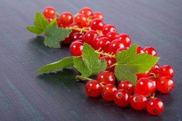 Branches of a red ripe currant lie on a black background