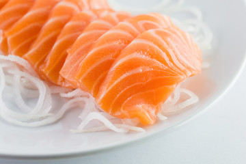salmon sashimi, raw on a plate on a white background