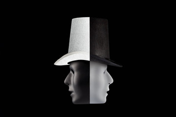 Black and white masks wearing top hat looking in opposite directions isolated on black background...
