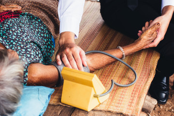 Male Doctor listening heart beat and breathing of Elderly Woman with Stethoscope with First Aid...