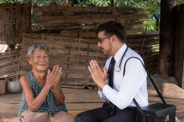Male Doctor listening heart beat and breathing of Elderly Woman with Stethoscope with First Aid...